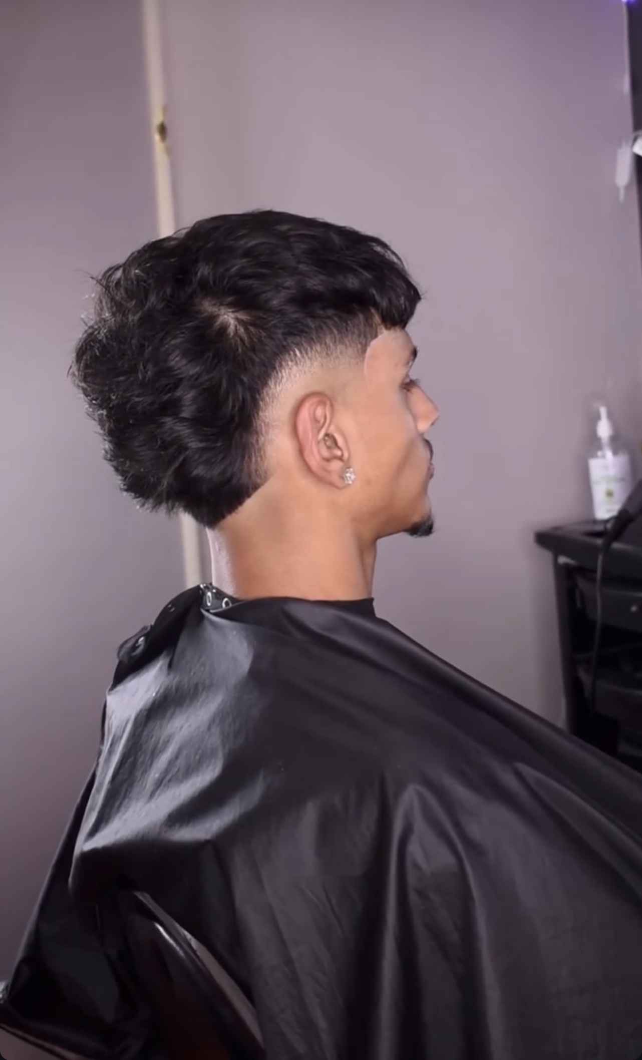 Black cape haircut with a textured taper